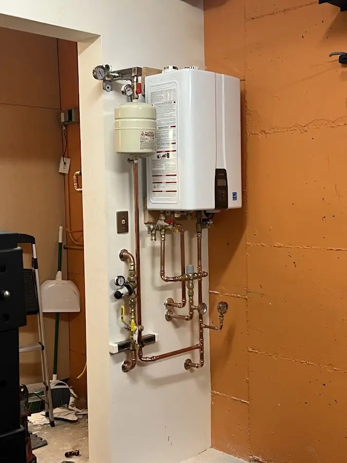 Plumbing technician inspecting water heater connections in Groveland